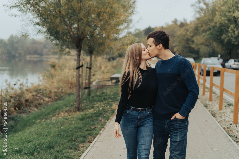 Young couple walking in a park, kissing Young couple walking in a park, kissing