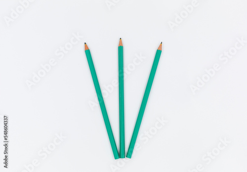 green pencils on a white background. The most important tool for a student  Pencils