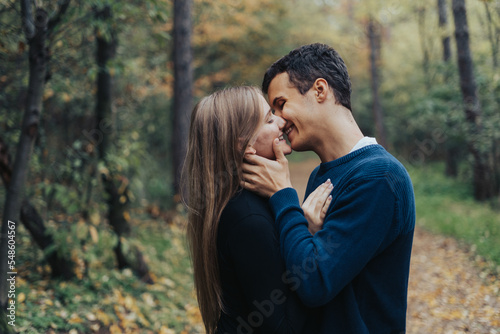 Romantic young couple kissing in a forest