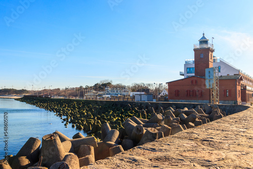 Old brick lighthouse at the Wieprza river mouth to the Baltic Sea in Darlowko, Poland photo