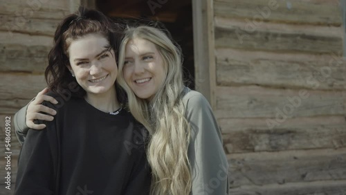 Portrait of smiling teenage girls hugging in ghost town / Grafton, Utah, United States photo