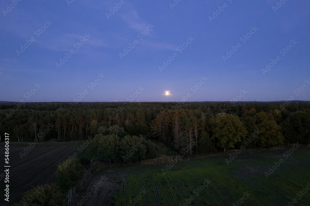 full moon at sunset in the countryside. Aerial night landscape shooting.