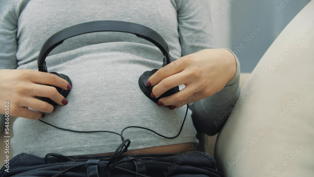 4k slow motion video of pregnant woman with headphones on stomach. 4k slow motion video of pregnant woman with headphones on stomach.