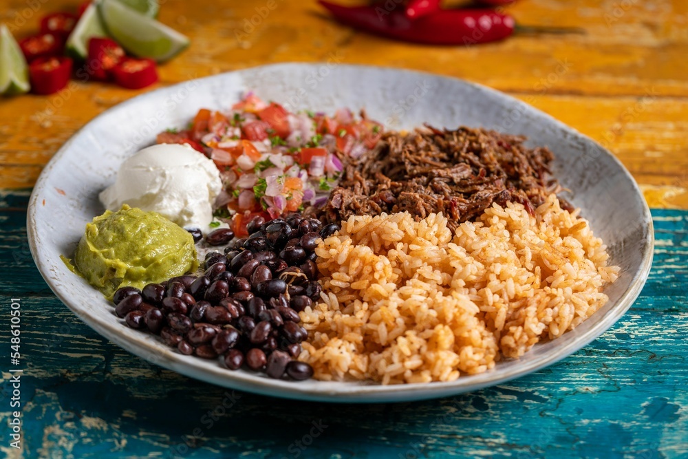 Φωτογραφία Tasty barbacoa burrito bowl, meat rice black beans sour cream guacamole and chop