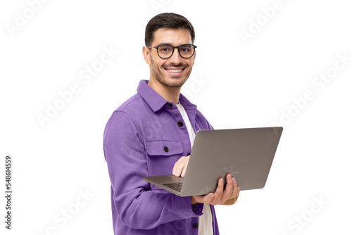 Portrait of young modern business man standing in casual purple shirt, holding laptop and looking at camera with happy smile