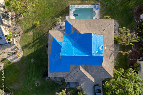 Wallpaper Mural Hurricane Ian destroyed homes in Florida residential area blue tarp roof. Natural disaster and its consequences Torontodigital.ca