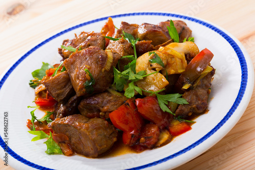 Portion of stewed beef with mushrooms, bell pepper, onion garnished with parsley