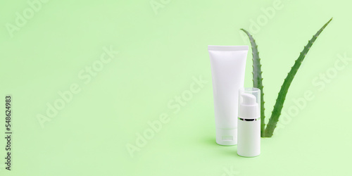 Blank cosmetics tube and dispenser with aloe vera on background.Organic cosmetic concept,large banner with negative space.