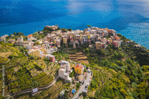 Corniglia village with colorful houses Cinque Terre is a famous seaside attraction. On the shores of the Ligurian Sea high above the cliffs in northwestern Italy. Sunny september 2022 aerial view.