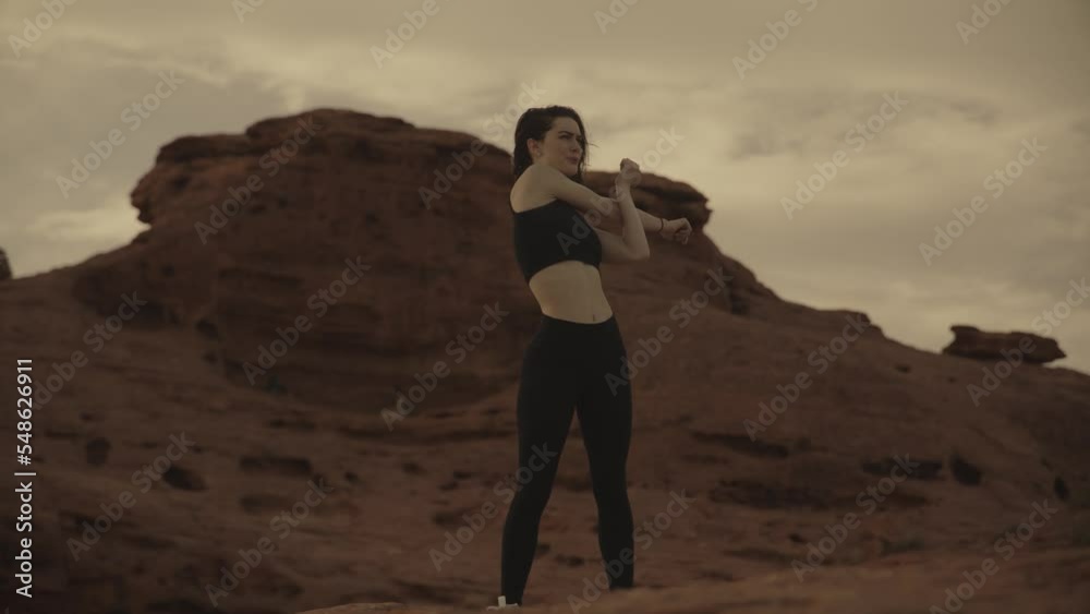 Slow motion low angle view of teenage girls stretching arms in desert / St. George, Utah, United States Slow motion low angle view of teenage girls stretching arms in desert / St. George, Utah, United States