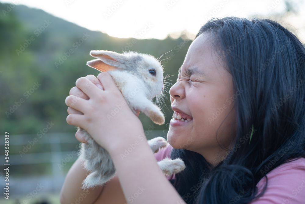 teenage girl with the rabbit. happy little girl holding cute fluffy