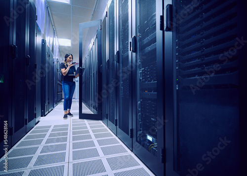 Female technician working in server room photo