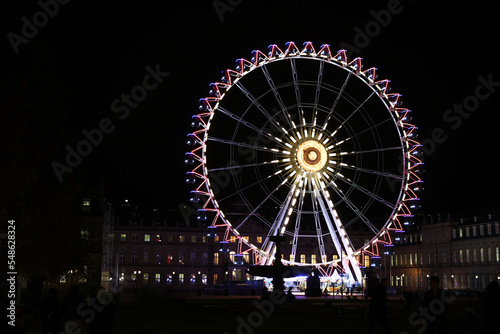 Colorfull ferris wheel at night in europe on the main square near Christmas market with soft focus