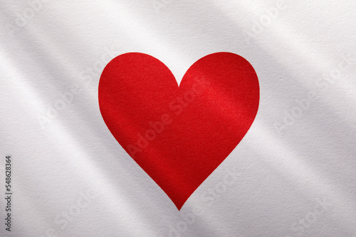 Red heart on white background with sunbeams photo