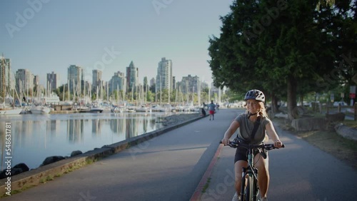 Girl biking along the seawall trail in stanley park, vancouver, british columbia
