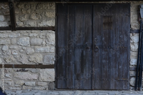 Entrance of building with old wooden doors in stone wall outdoors