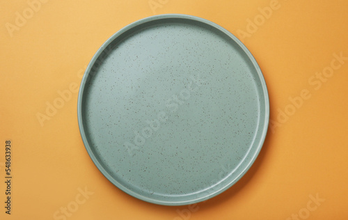 Konstfotografi Empty ceramic plate on pale orange background, top view