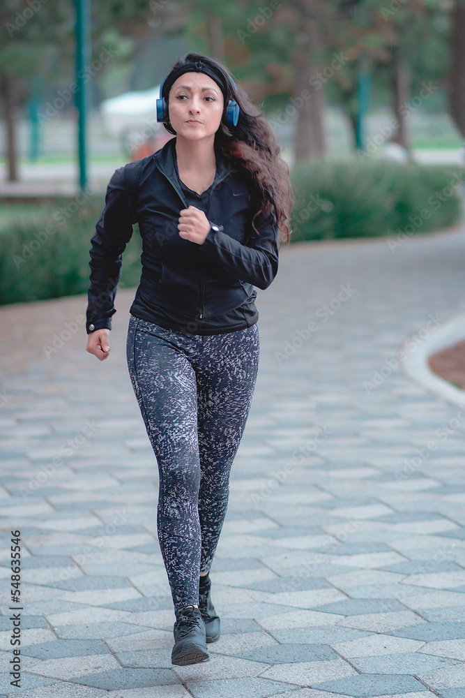 Woman running on the path of a park. Healthy lifestyle concept. Athletic sports exercises for athletic people. Woman running on the path of a park. Healthy lifestyle concept. Athletic sports exercises for athletic people.