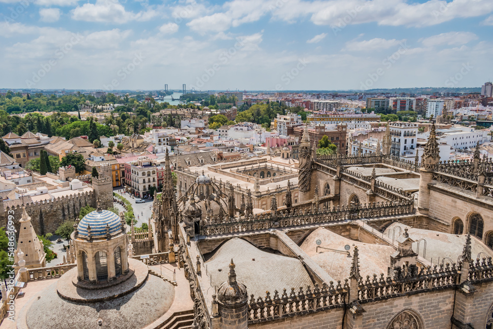 Architecture and Gothic decoration of Seville Cathedral and Alcazar with aerial view over the city with Guadalquivir river in the background, SPAIN