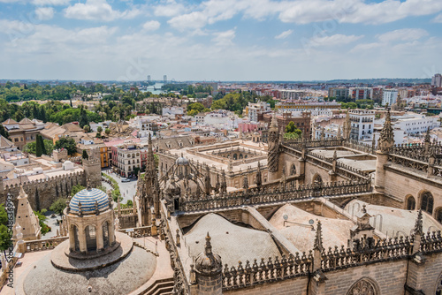 Architecture and Gothic decoration of Seville Cathedral and Alcazar with aerial view over the city with Guadalquivir river in the background, SPAIN