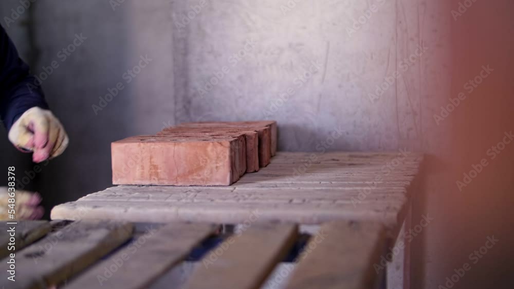 builder folds bricks, hands close up builder folds bricks, hands close up