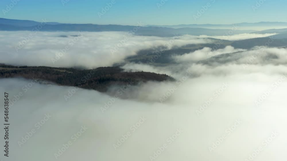 Aerial establishing shot over cloudy forest, flying towards mountain range. Aerial establishing shot over cloudy forest, flying towards mountain range.