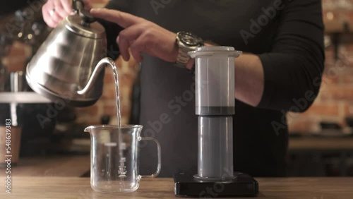 Barista making Aeropress coffee, press to device and coffee drops pours trought aeropress to teapot photo