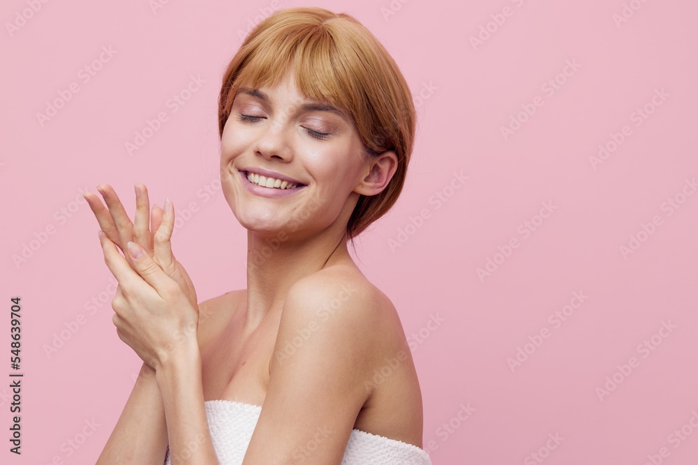 an attractive, gentle woman with short hair and clean skin stands on a pink background, covering her eyes with pleasure, posing with her hands in a relaxed manner an attractive, gentle woman with short hair and clean skin stands on a pink background, covering her eyes with pleasure, posing with her hands in a relaxed manner