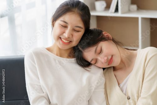 Happy LGBTQ Asian Lesbian Couple Two Asian girls show their love by cuddling and having romance together at home. Positive emotions and LGBT lesbian moments.