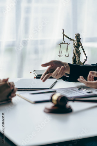 Obraz na płótnie Business lawyers working on law in a courtroom help clients read legal documents and study information about court cases, along with a justice scale and hammer