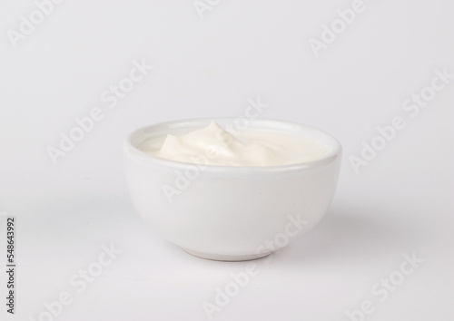 A jar with white sauce on a white background.