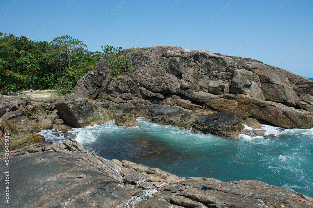 .Natural landscape in the Escape of Islands, Barra do Sahy, São Sebastião, Brazil. As Ilhas. Turquoise sea and waves hitting the rocks.