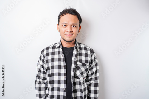 A portrait of a happy Asian man wearing tartan shirt is smiling isolated by white background