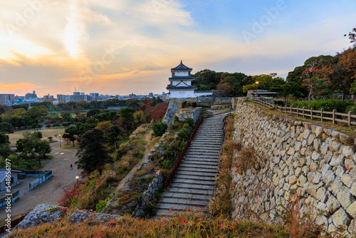 Stairs to castle lookout atop stone wall over city at sunset