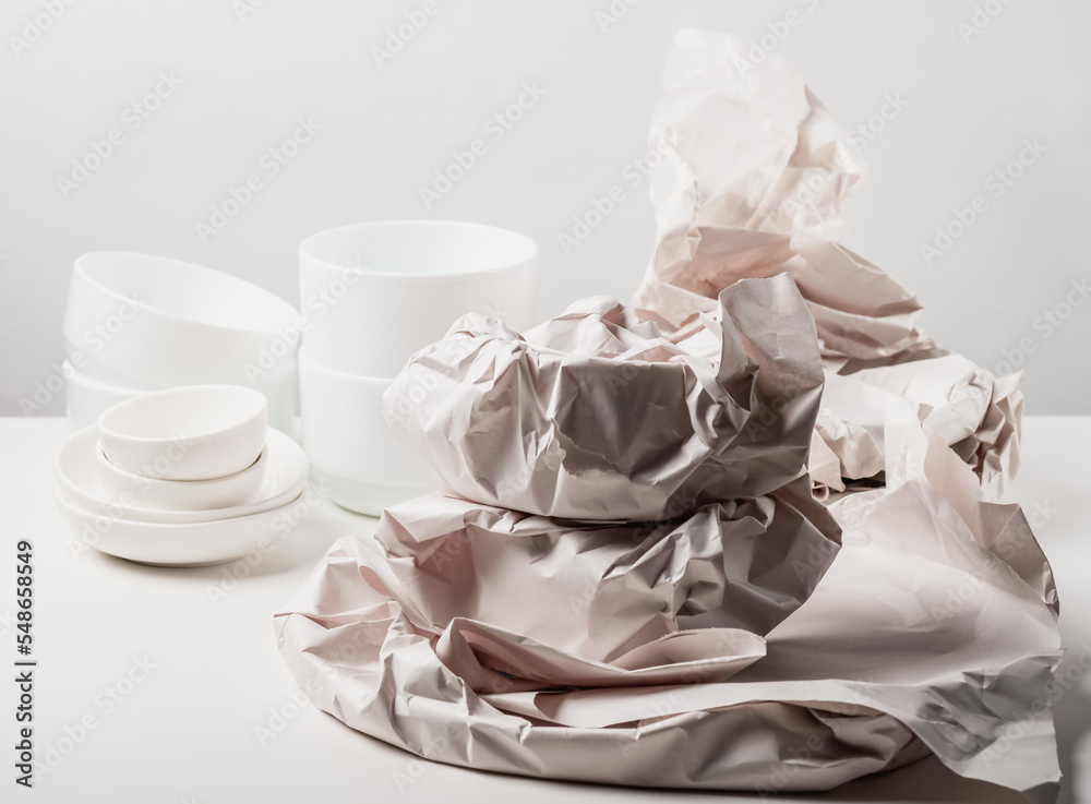Unpacking new ceramic whiteware. Paper packaging for fragile items. Ecological packaging