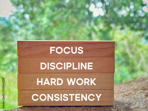 Focus discipline hard work consistency text on wooden blocks background. Inspirational and Motivational Concept. photo