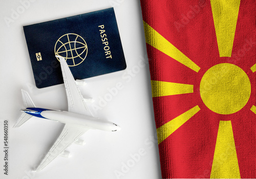 Flag of North Macedonia with passport and toy airplane. Flight travel concept 
