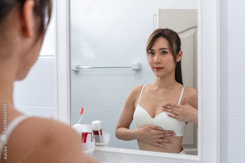 Breast Cancer, World cancer day. Young Asian woman examining, palpation for a lump or cancer in the breast. Breast Cancer, World cancer day. Young Asian woman examining, palpation for a lump or cancer in the breast.