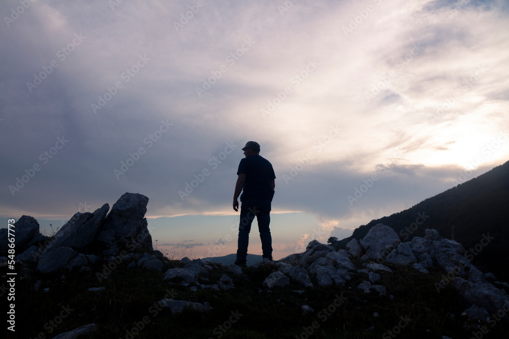 hiker on the mountain summit at sunset in the Matese park