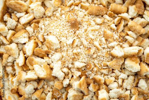 Close-up of a pile dried broken pieces of biscuit, heap of sweet bread crumbs, top view.