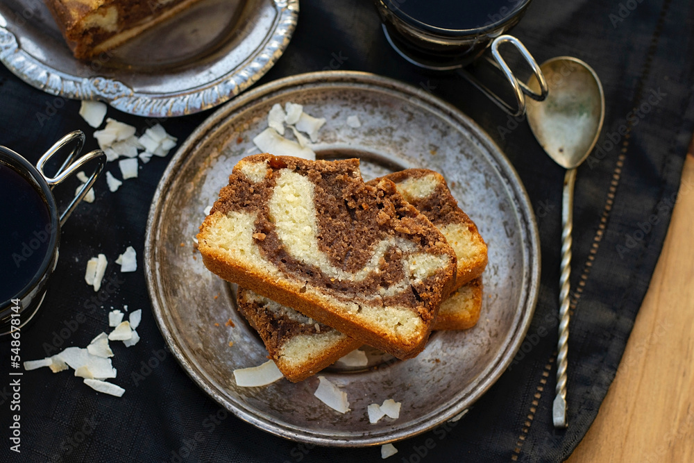 Slices of marble cake with coconut served with coffee Slices of marble cake with coconut served with coffee