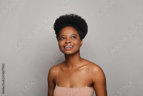  Happy woman with fresh skin looking up on white studio wall background. Beauty, facial treatment, skin care and wellness concept