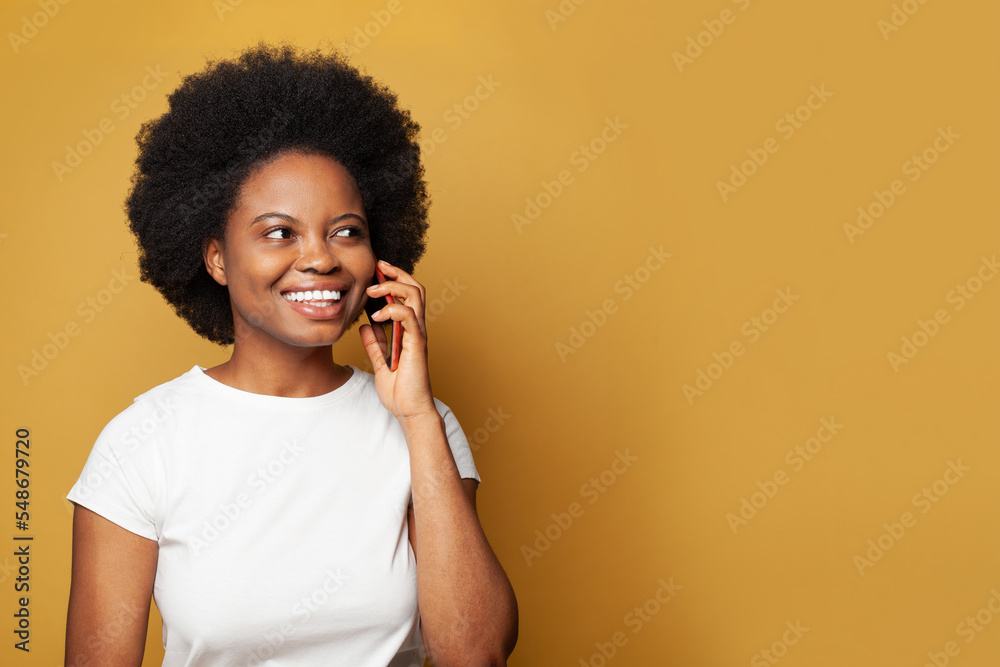 Young beautiful woman brunette in casual white empty t-shirt using smartphone against yellow studio wall banner background Young beautiful woman brunette in casual white empty t-shirt using smartphone against yellow studio wall banner background