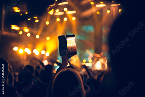 Person holding modern smartphone on a concert.