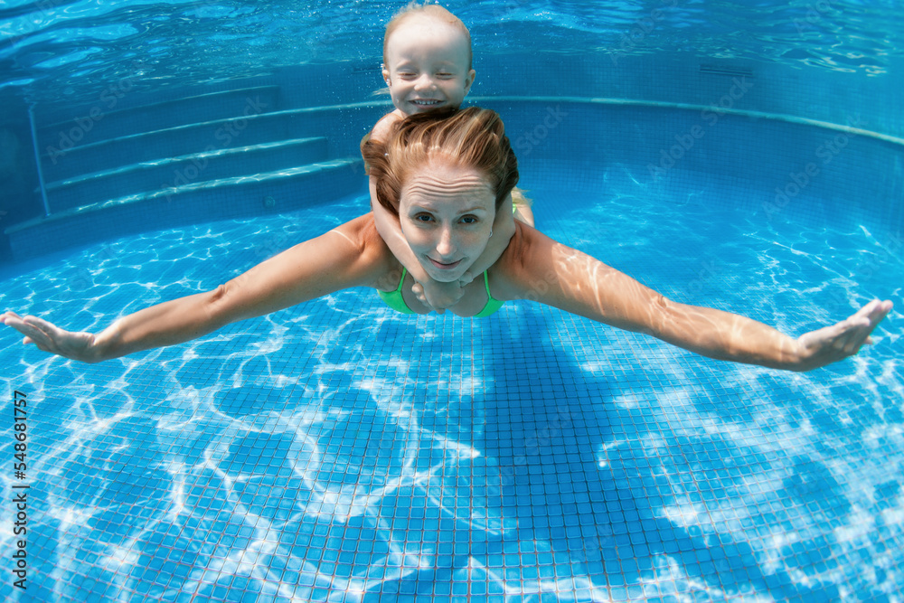 Happy family young mother, baby boy learn to swim, dive underwater
