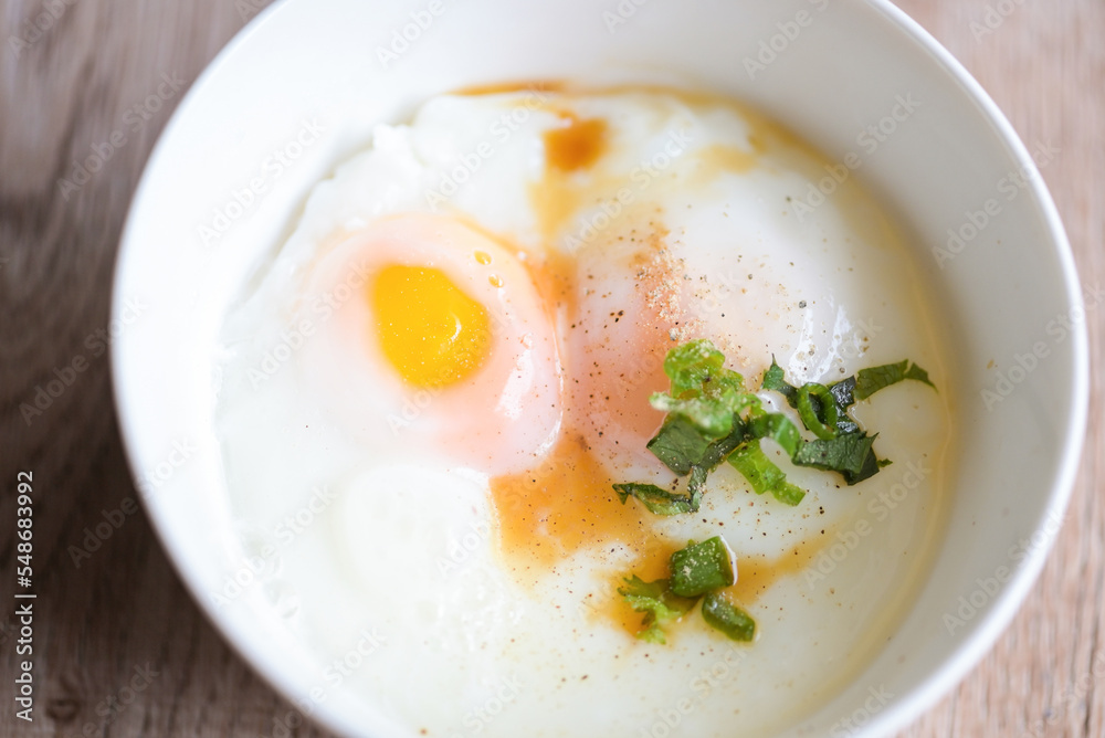 soft-boiled eggs on white bowl with pepper coriander on wooden table, egg breakfast, onsen egg soft-boiled eggs on white bowl with pepper coriander on wooden table, egg breakfast, onsen egg