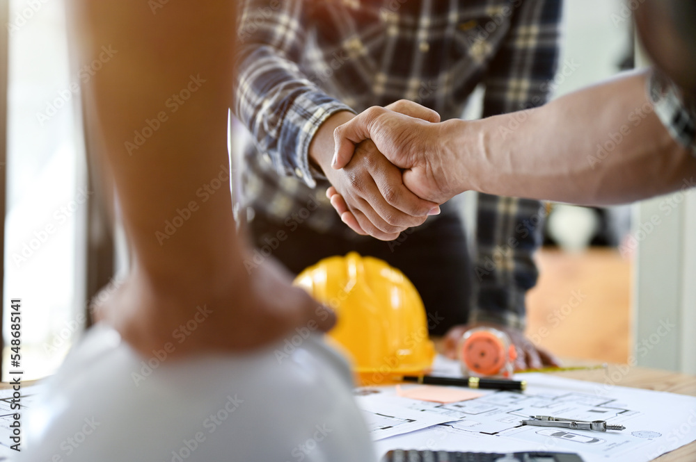 Professional Asian male engineer shaking hands with male architect after the meeting - obrazy, fototapety, plakaty 
