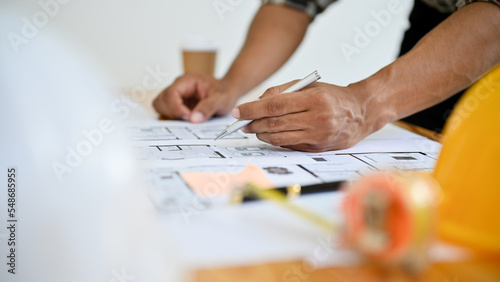 close-up, Professional Asian male construction engineer working on blueprint in the office.