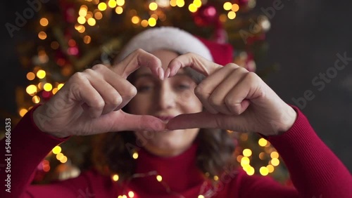 white woman face view through heart shape joined fingers, blogger share love photo