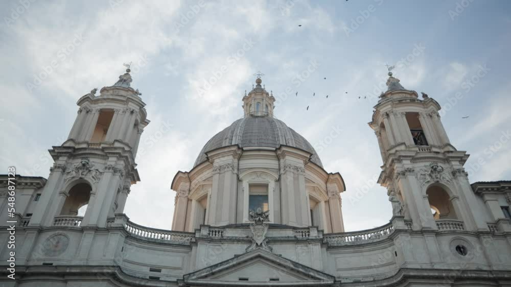 Church Of Sant'Agnese in Agone Against Sky With Birds Flying In Rome, Italy - low angle shot Church Of Sant'Agnese in Agone Against Sky With Birds Flying In Rome, Italy - low angle shot